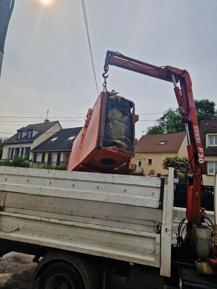 Ancienne chaudière fioul levée à la grue sur un camion